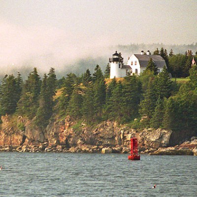 a small boat in a body of water with a mountain in the background