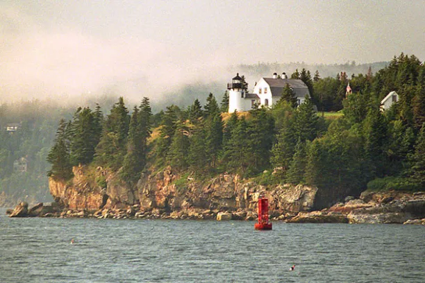 a small boat in a body of water with a mountain in the background