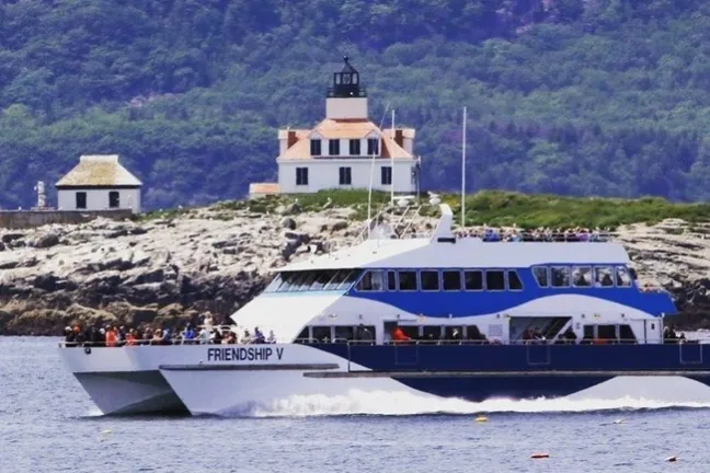 a small boat in a body of water with a mountain in the background