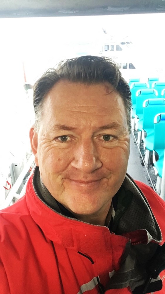 a man wearing glasses and smiling at the camera